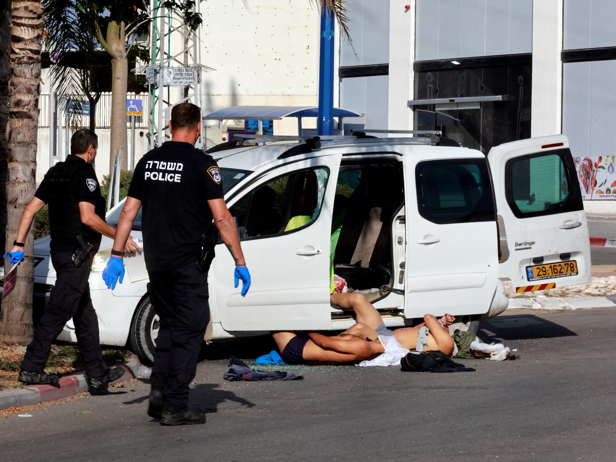 La policía israelí se acerca a los cuerpos de dos hombres que murieron tras una infiltración masiva de hombres armados de Hamás desde la Franja de Gaza, en Sderot, en el sur de Israel.